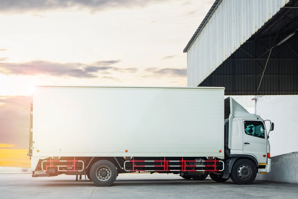 A temperature-controlled truck parked at a warehouse