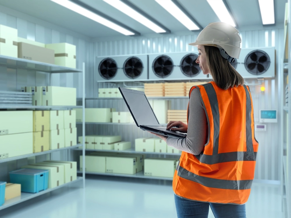 A warehouse technician takes inventory inside a refrigerated storage facility